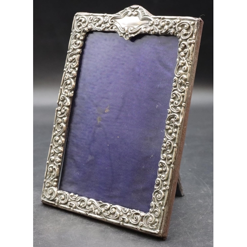 260 - A silver mounted freestanding photograph frame with allover embossed floral, leaf and scroll decorat... 