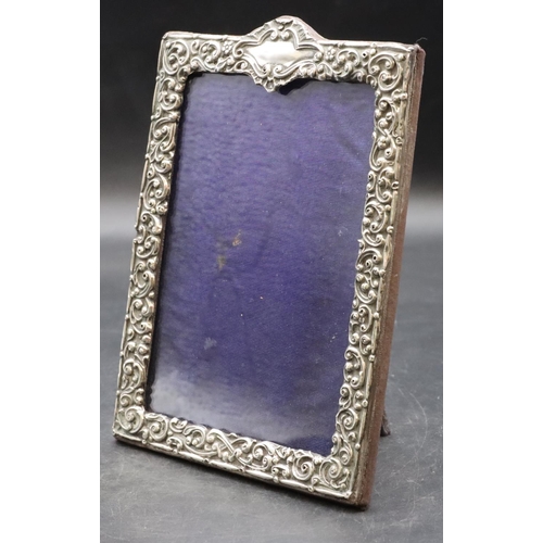 260 - A silver mounted freestanding photograph frame with allover embossed floral, leaf and scroll decorat... 