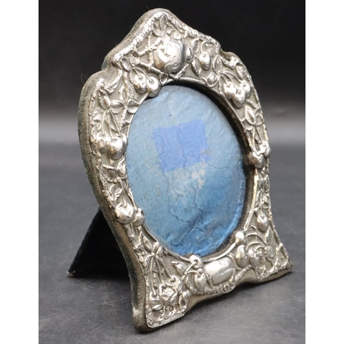 261 - A Birmingham silver freestanding photograph frame with embossed cherry, leaf and scroll decoration, ... 