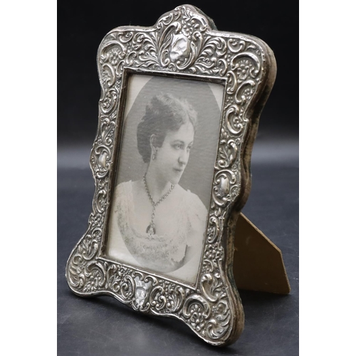 264 - A Chester silver mounted freestanding rectangular scallop shaped photograph frame with embossed flor... 