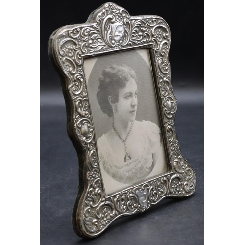 264 - A Chester silver mounted freestanding rectangular scallop shaped photograph frame with embossed flor... 