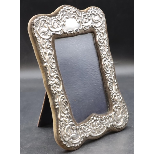 265 - A London silver mounted freestanding photograph frame with embossed bird, shell and scroll decoratio... 