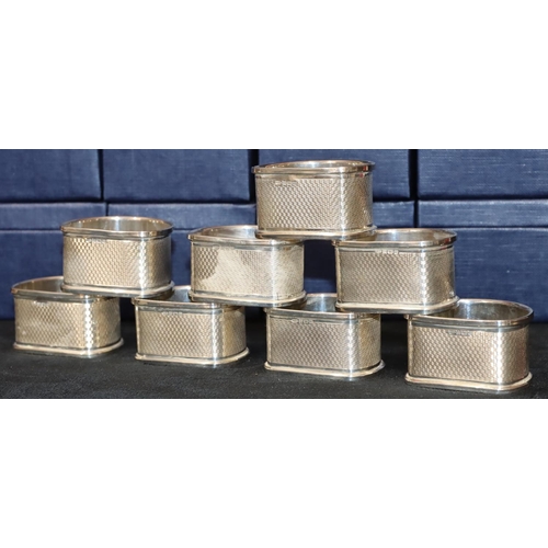 279 - A set of 8 modern Broadway & Co. Birmingham silver half round napkin rings with engine turned decora... 