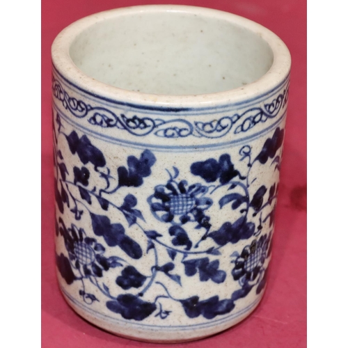 43 - An Oriental cylindrical blue and white brush pot with floral and leaf decoration, 12.5cm high