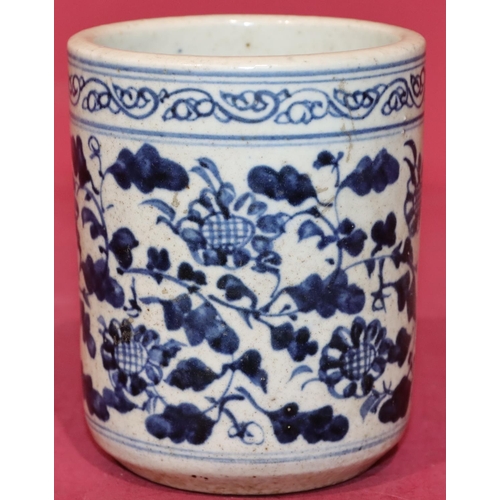 43 - An Oriental cylindrical blue and white brush pot with floral and leaf decoration, 12.5cm high