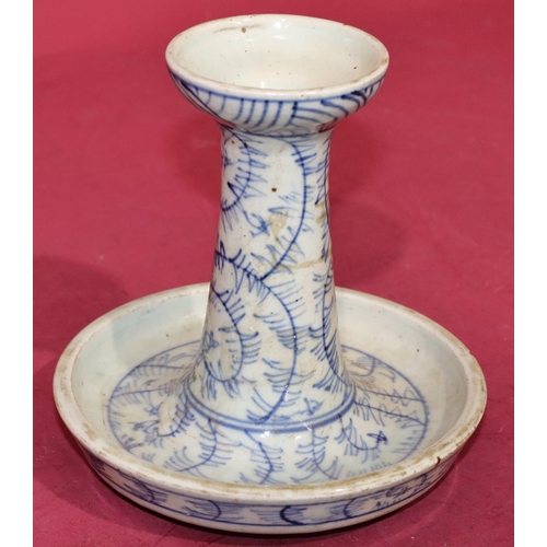 44 - An Oriental blue and white round candlestick on circular base (chip to rim), 15cm high