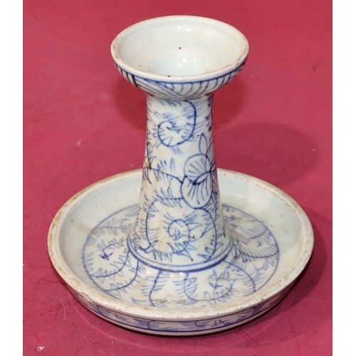 44 - An Oriental blue and white round candlestick on circular base (chip to rim), 15cm high