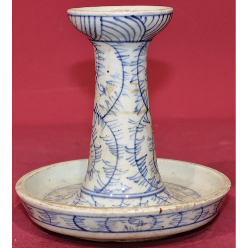 44 - An Oriental blue and white round candlestick on circular base (chip to rim), 15cm high