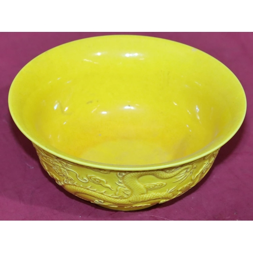 46 - An Oriental round trumpet shaped bowl on yellow ground with raised dragon decoration, 18cm diameter