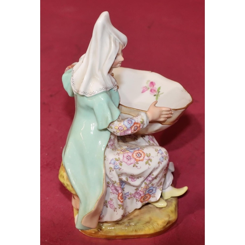 54 - A Meissen salt in the form of a seated young lady holding a shell with multi-coloured floral and lea... 