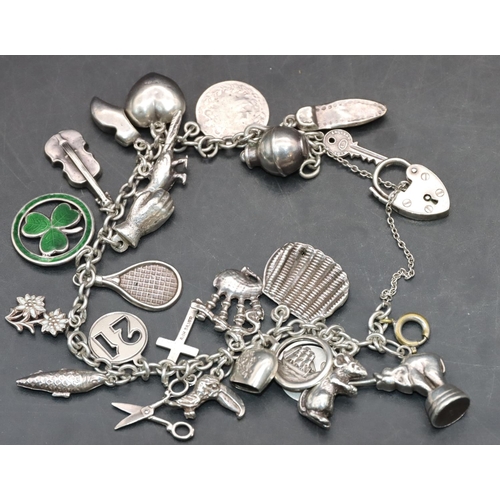 540 - A silver charm bracelet mounted with padlock clasp and 23 charms, 43 grams