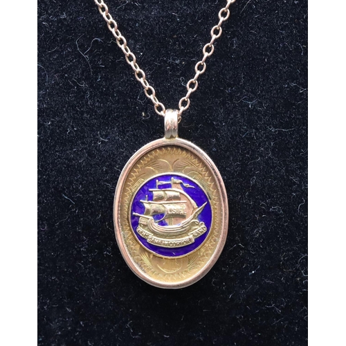 551 - A 9ct gold oval pendant inscribed to reverse, with chain and blue enamelled decoration (part enamel ... 