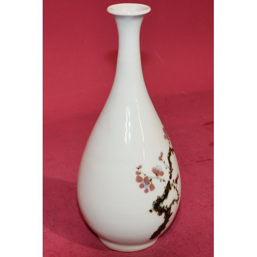 62 - An Oriental round bulbous thin necked trumpet shaped vase on white ground with multi-coloured branch... 