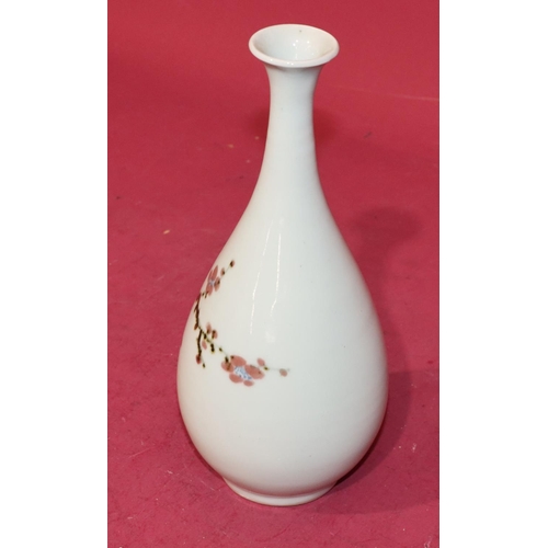 62 - An Oriental round bulbous thin necked trumpet shaped vase on white ground with multi-coloured branch... 