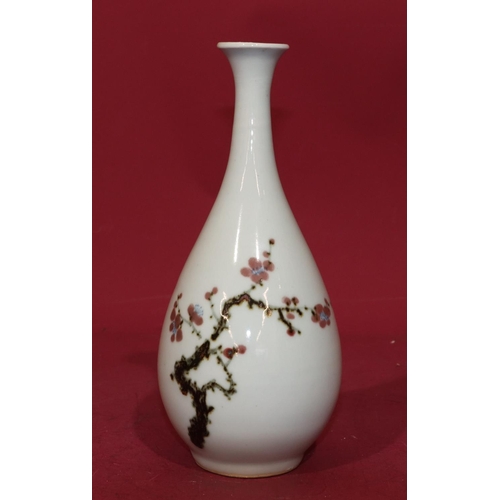 62 - An Oriental round bulbous thin necked trumpet shaped vase on white ground with multi-coloured branch... 