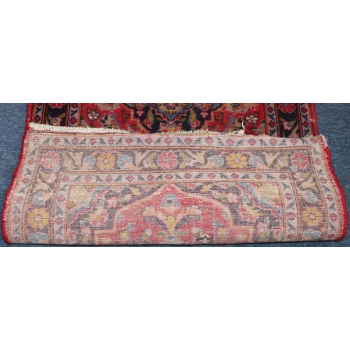 621 - A small Persian style rug on red and blue ground with centre medallion, 138cm x 76cm