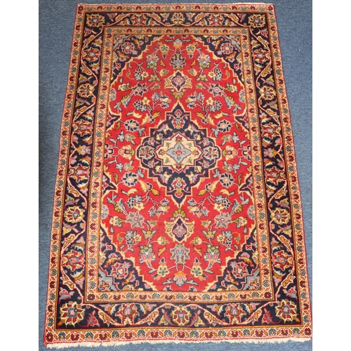 623 - A Persian style rug on red and blue ground with centre medallions, 155cm x 97cm