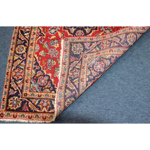 623 - A Persian style rug on red and blue ground with centre medallions, 155cm x 97cm