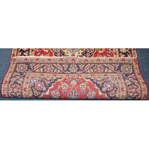 623 - A Persian style rug on red and blue ground with centre medallions, 155cm x 97cm