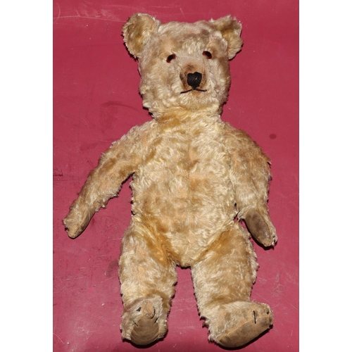 652 - An antique teddy bear with glass eyes (some wear and arms in need of re-padding), 45cm high