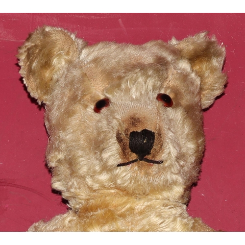 652 - An antique teddy bear with glass eyes (some wear and arms in need of re-padding), 45cm high