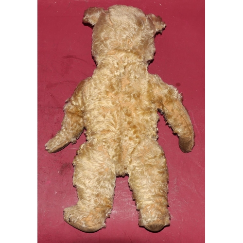 652 - An antique teddy bear with glass eyes (some wear and arms in need of re-padding), 45cm high