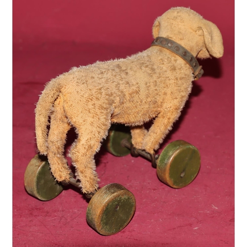 653 - An early pre-war Steiff Dachshund pull toy (1 glass eye missing and worn all over) on green painted ... 