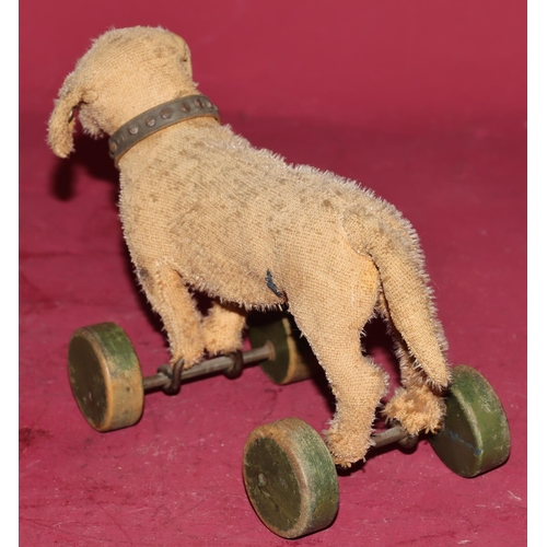 653 - An early pre-war Steiff Dachshund pull toy (1 glass eye missing and worn all over) on green painted ... 