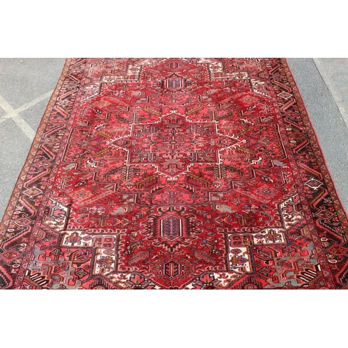 686 - A Persian carpet on red ground with centre medallion, 391cm x 300cm