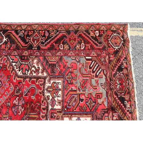 686 - A Persian carpet on red ground with centre medallion, 391cm x 300cm