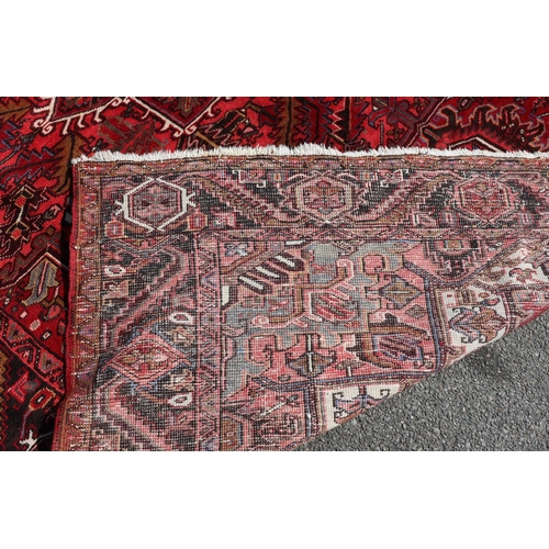 686 - A Persian carpet on red ground with centre medallion, 391cm x 300cm