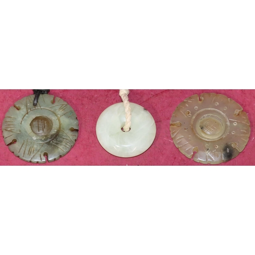 713 - A jade style circular disc shaped pendant and 2 similar pendants (3)