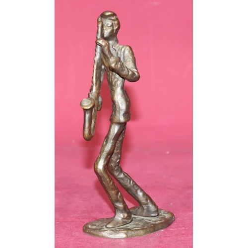 721 - A bronze figure of a saxophonist on scallop shaped base, 21.5cm high