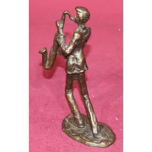 721 - A bronze figure of a saxophonist on scallop shaped base, 21.5cm high