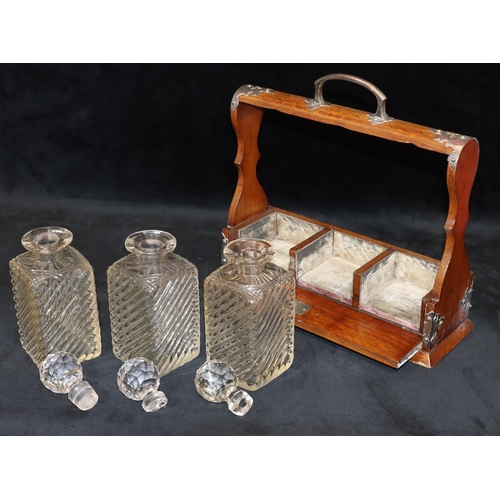 728 - An oak 3-bottled tantalus with silver plated handle and mounts, set with 3 cut glass square decanter... 