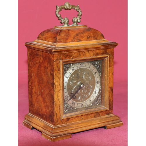 743 - A modern burr walnut timepiece with centre brass carrying handle with square dial and Roman numerals... 