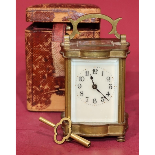 744 - A miniature brass carriage clock with cream enamel dial and Arabic numerals, swing overhead handle o... 