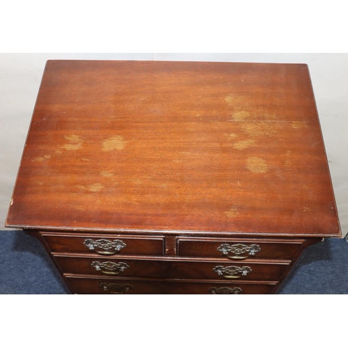 763 - A reproduction chest of drawers with 2 short and 4 long graduated drawers below with drop brass hand... 