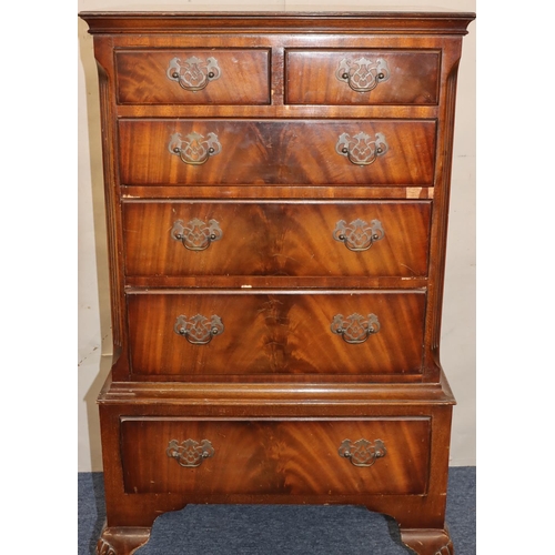 763 - A reproduction chest of drawers with 2 short and 4 long graduated drawers below with drop brass hand... 