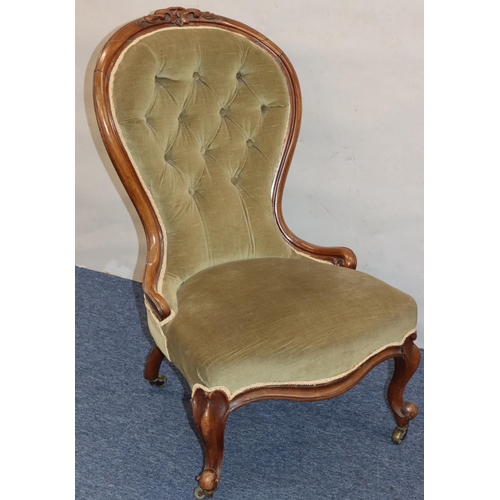 768 - A Victorian walnut spoon back nursing chair with green velvet overstuffed seat and button back, on c... 