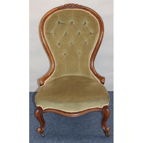 768 - A Victorian walnut spoon back nursing chair with green velvet overstuffed seat and button back, on c... 