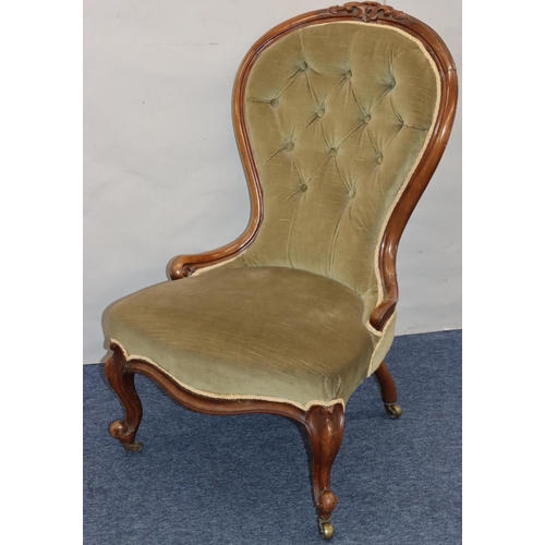 768 - A Victorian walnut spoon back nursing chair with green velvet overstuffed seat and button back, on c... 