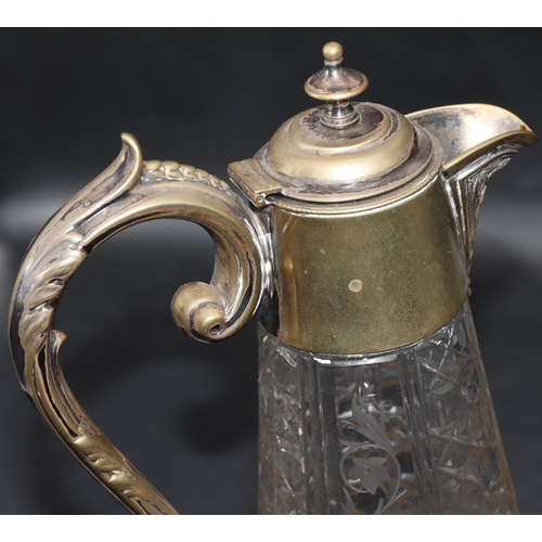 85 - A cut glass round bulbous claret jug with silver plated neck, hinged lid and scroll handle with allo... 