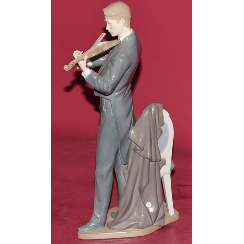 86 - A large Lladro figure of a standing violinist next to a chair, 38.5cm high