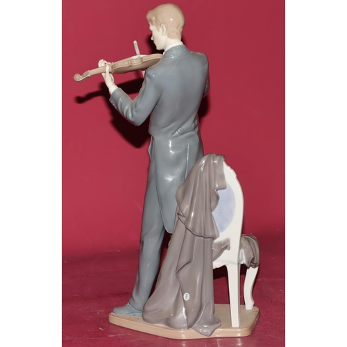 86 - A large Lladro figure of a standing violinist next to a chair, 38.5cm high