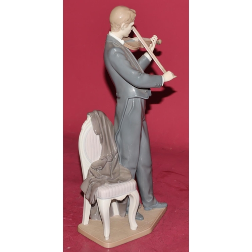 86 - A large Lladro figure of a standing violinist next to a chair, 38.5cm high