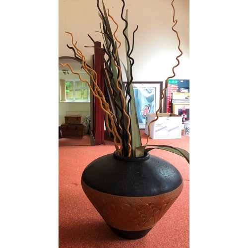 4284 - A patterned earthenware pot, 52cm diameter, 42cm high and various dries branches and leaves.