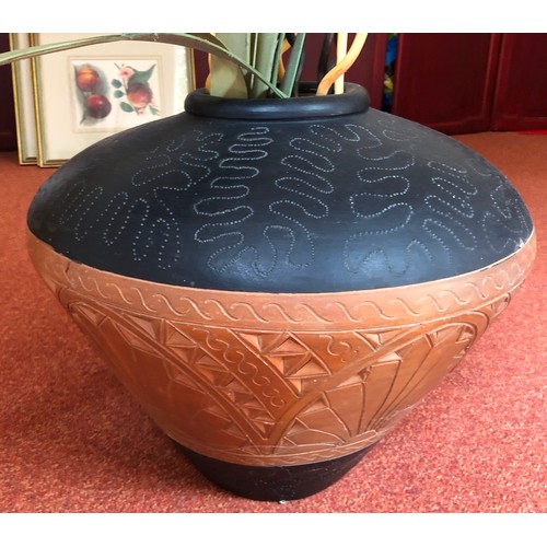 4284 - A patterned earthenware pot, 52cm diameter, 42cm high and various dries branches and leaves.