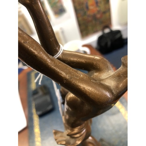 626 - An Art Deco spelter table lamp in the form of a half-naked standing lady holding a circular shade, o... 