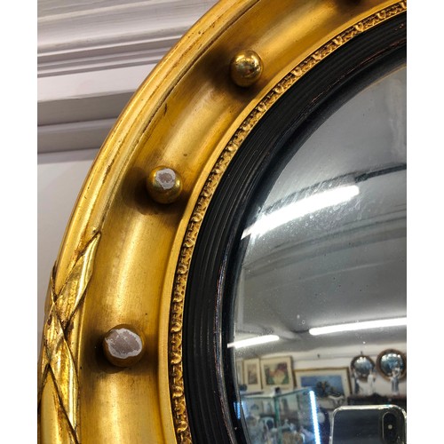 767 - A 19th/20th Century gilt convex mirror with inner ball rim, 42cm diameter (3 balls with gilt loss an... 